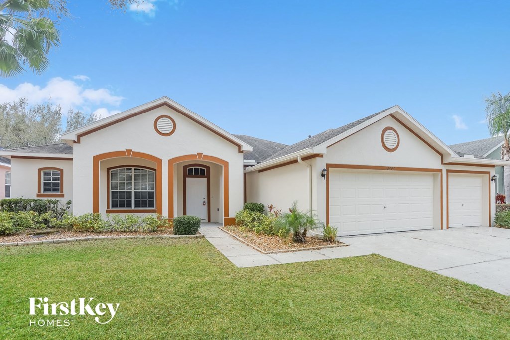 a beige house with a driveway and a garage door
