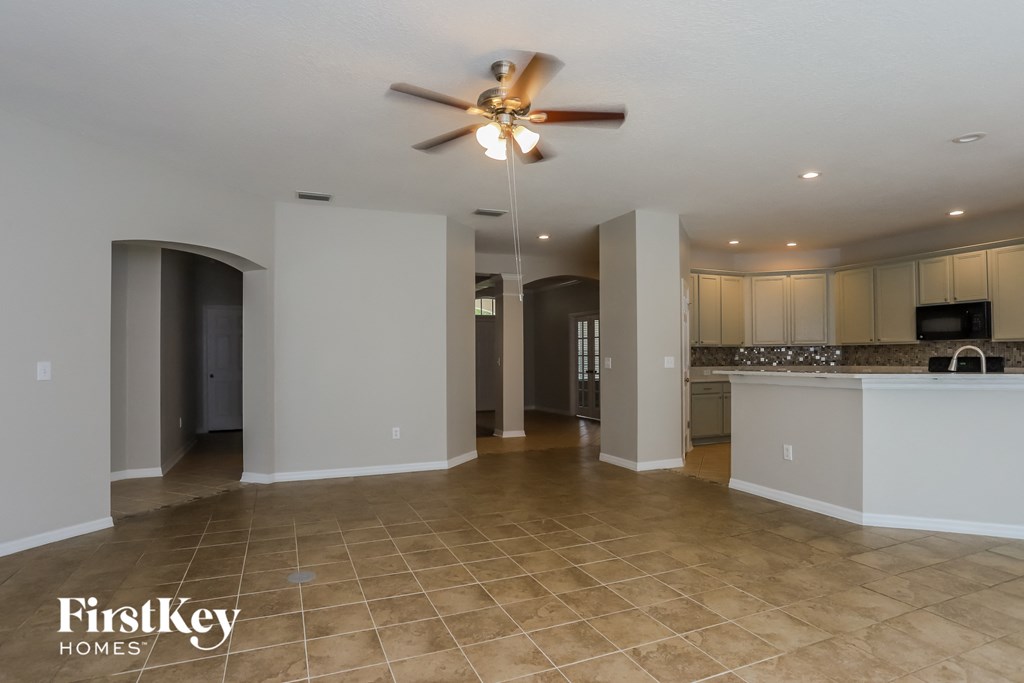 an empty kitchen and living room with a ceiling fan