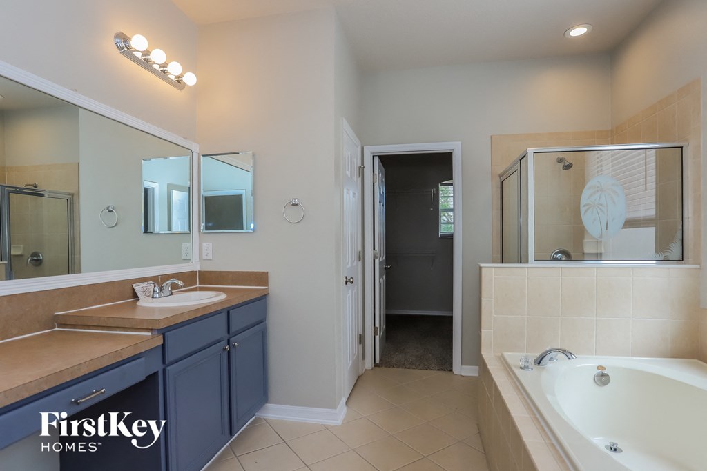 a blue and white bathroom with two sinks and a tub
