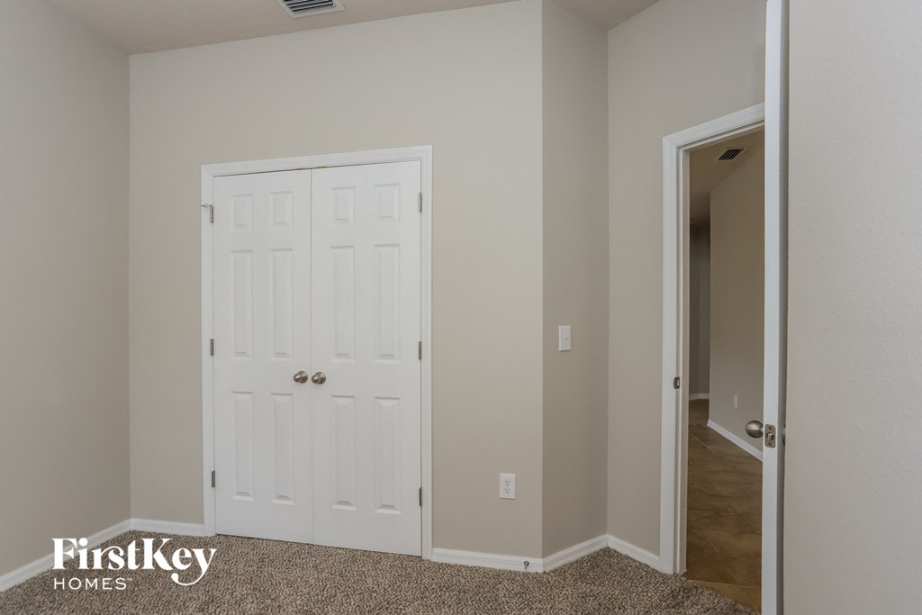a bedroom with a closet and a white door