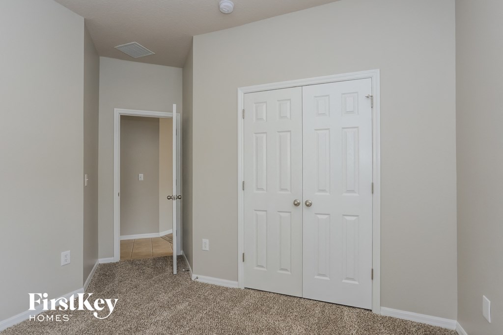 a bedroom with two closets and a door into a hallway