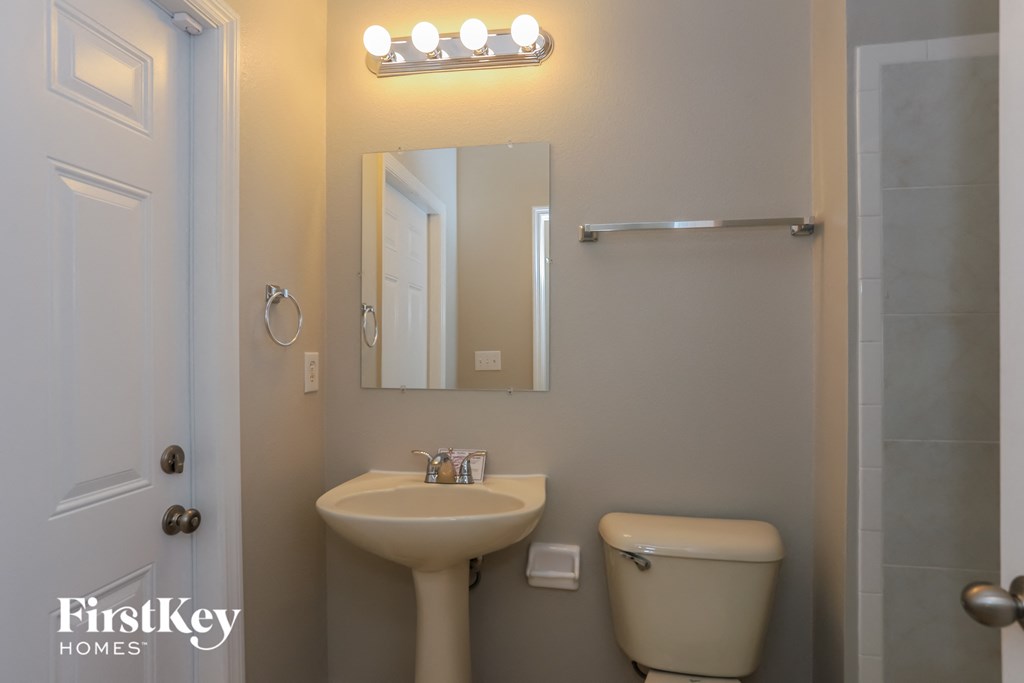 a small bathroom with a toilet sink and mirror and a shower
