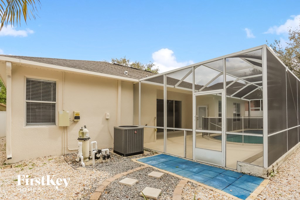 a small house with a pool and a screened in porch