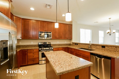 A kitchen with wooden cabinets and granite countertops.