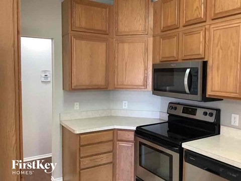 A kitchen with wooden cabinets and a black stove top oven.