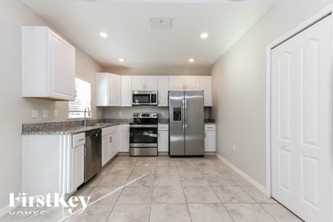 A kitchen with white cabinets and appliances.