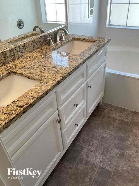 a bathroom with two sinks and a granite counter top