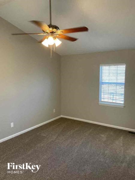 an empty room with a ceiling fan and a window