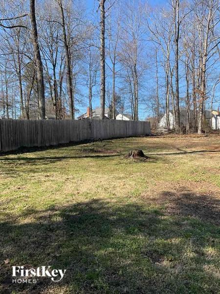 a backyard with a fence and some trees