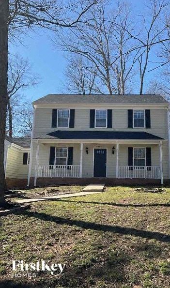a white house with a blue roof and a yard