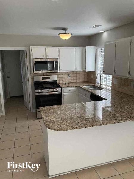 a kitchen with white cabinets and a granite counter top