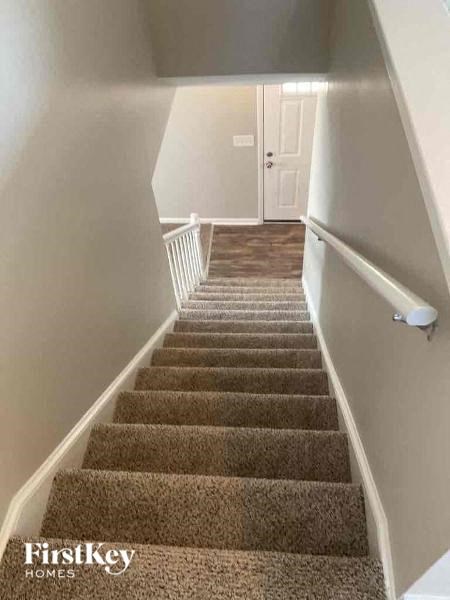 a staircase with carpeted stairs leading up to a white door