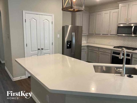 a kitchen with an island and a stainless steel refrigerator