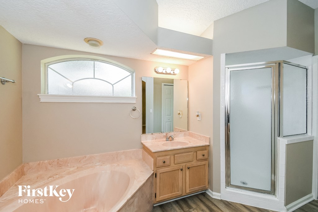 the master bathroom has a large tub and a shower