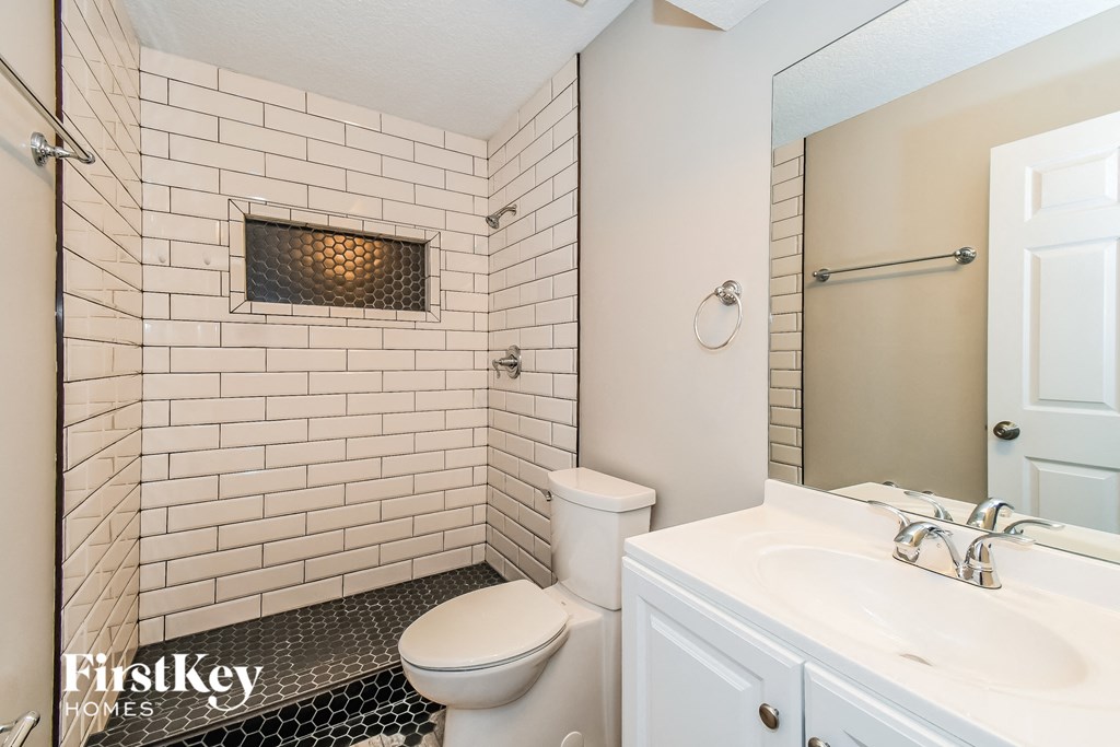 a white bathroom with a toilet and a sink