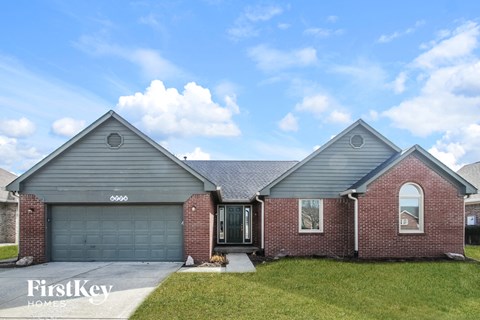 front exterior view of a brick home with gray siding and a gray garage door