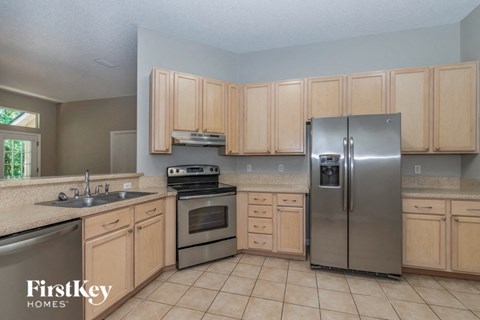 A kitchen with wooden cabinets and a stainless steel refrigerator.