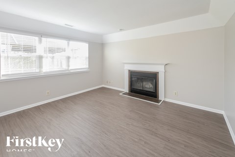 A spacious living room with a fireplace and wooden flooring.