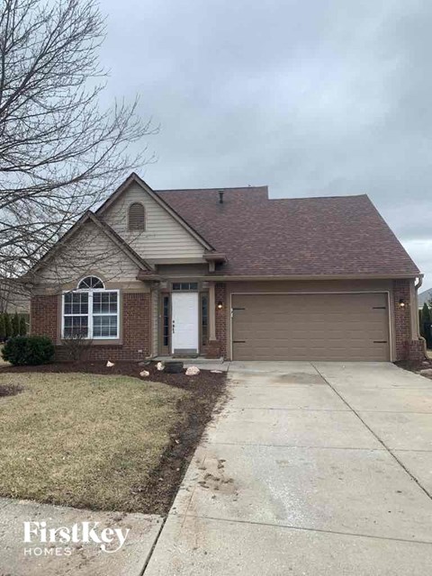 a brick house with a white door and a driveway