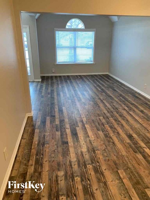 a living room with wood flooring in an empty house