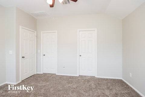 a bedroom with two doors and a carpeted floor