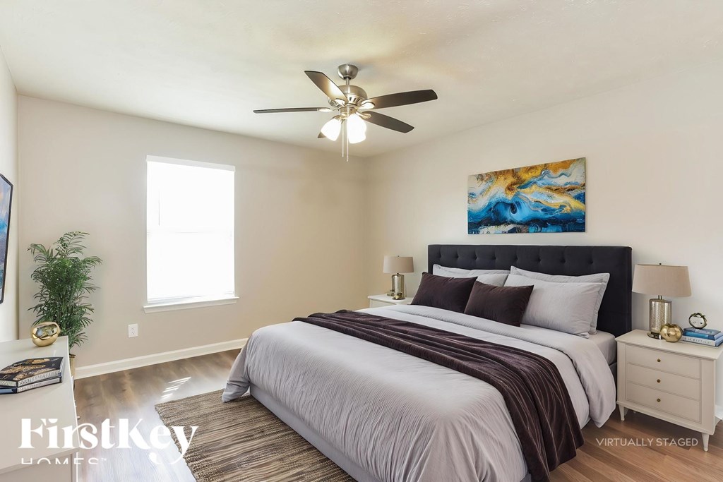 A bedroom with a large bed and a ceiling fan.