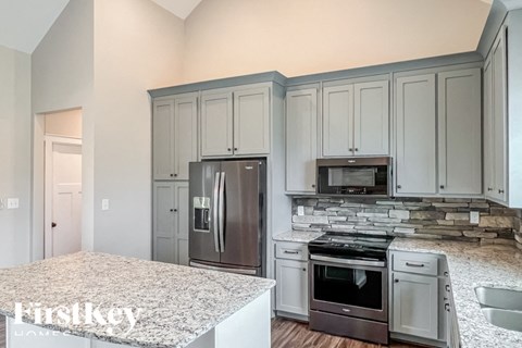 A kitchen with a granite countertop and stainless steel appliances.