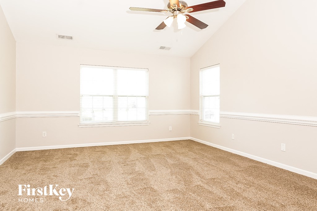 a bedroom with carpet and a ceiling fan