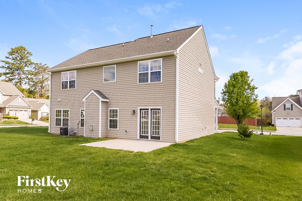 the backyard and front yard of a house with a yard and grass