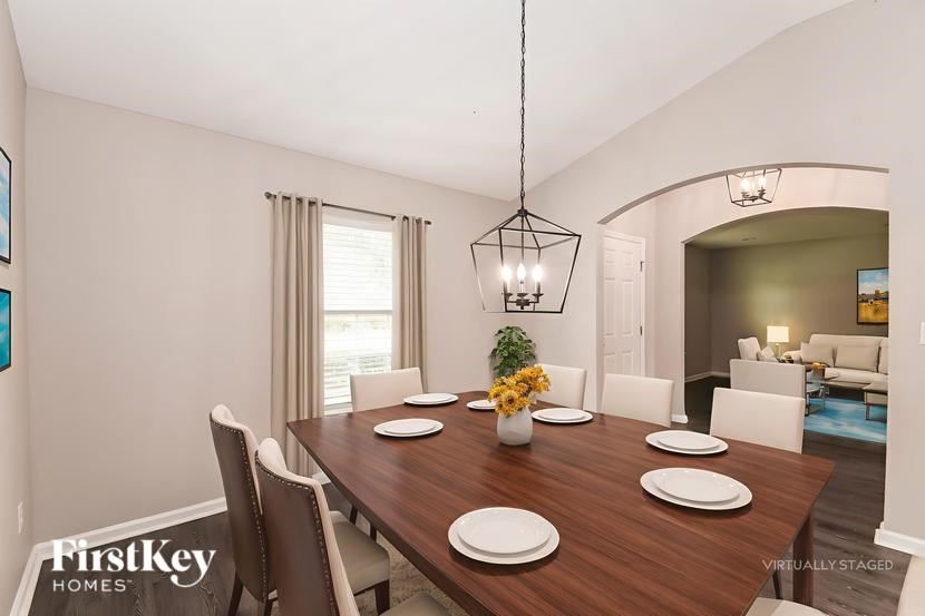 A dining room with a wooden table set for four.