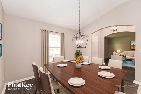A dining room with a wooden table set for four.