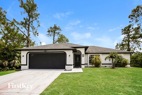 a white house with a black garage door