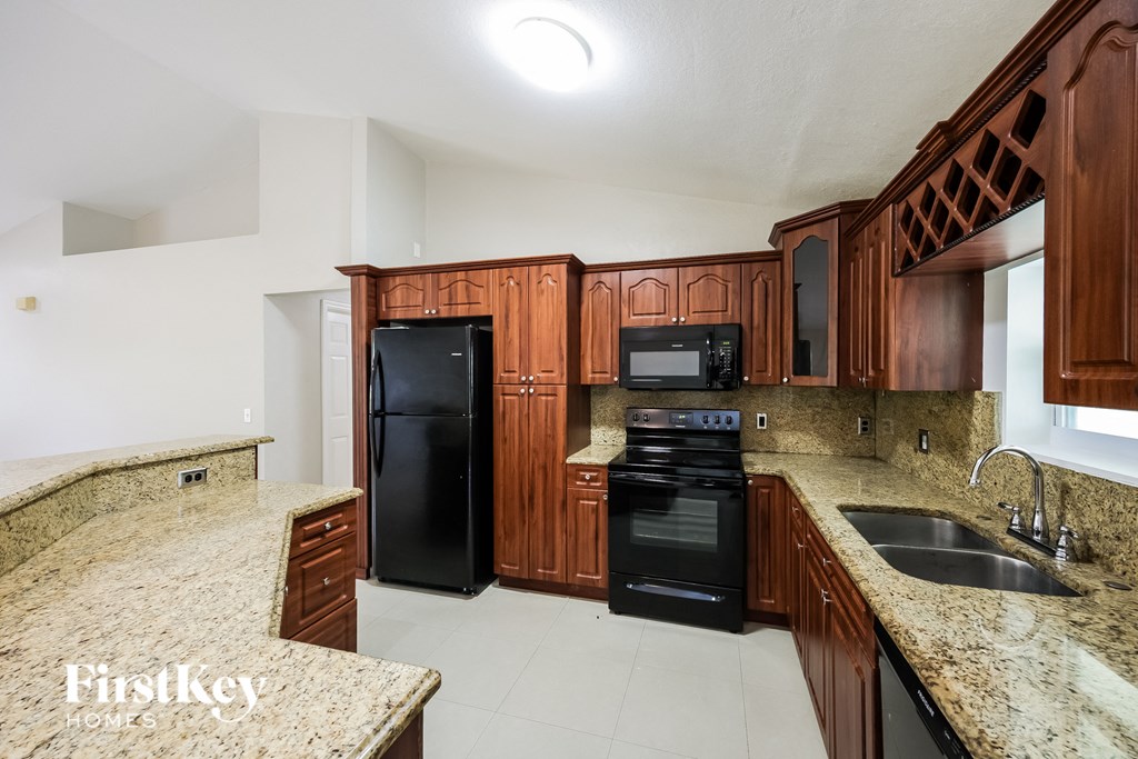 a kitchen with black appliances and granite counter tops