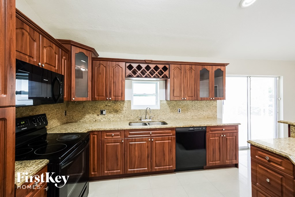 a kitchen with wooden cabinets and black appliances