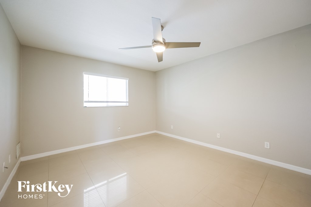 a empty room with a ceiling fan and a window