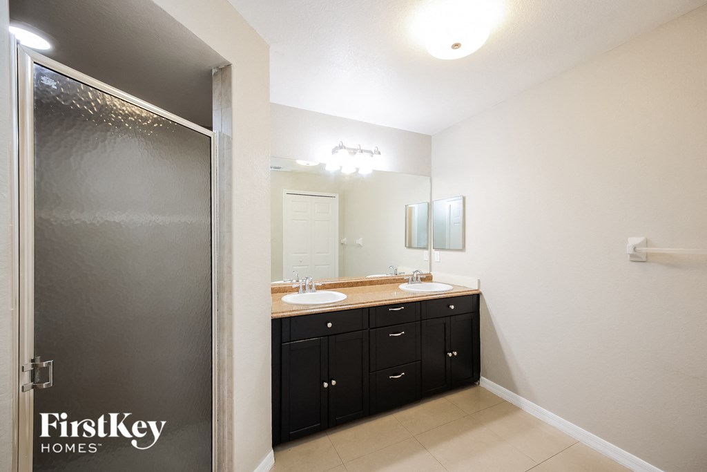 a black and white bathroom with two sinks and a shower