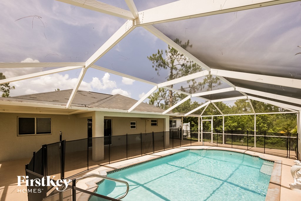 the pool is protected by a patio roof and a fence around it