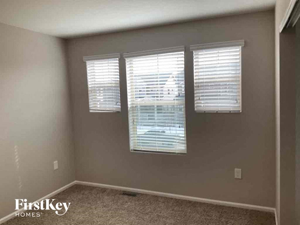 a room with three windows with blinds in it