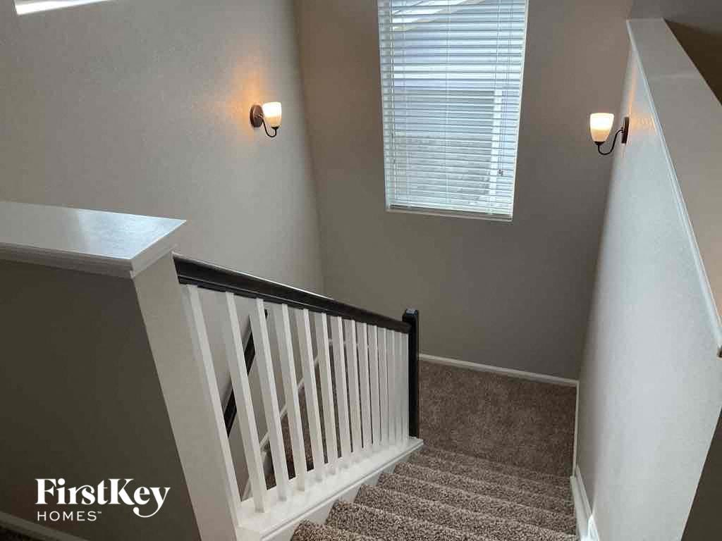 the stairway in a home with a staircase railing and a window with two lights