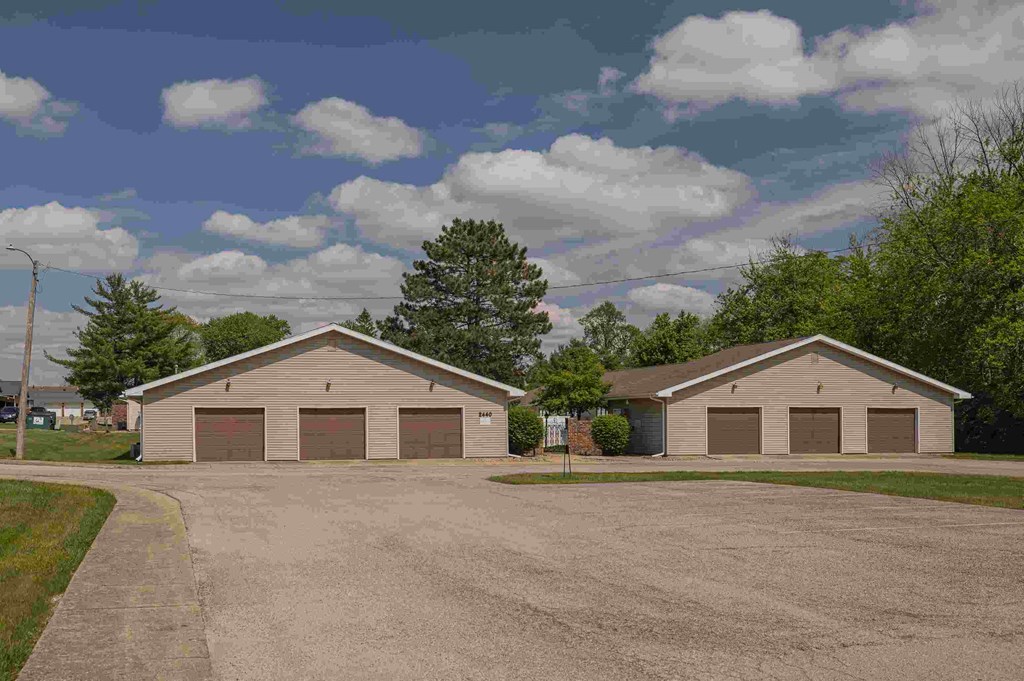 Two garages are situated in a parking lot.