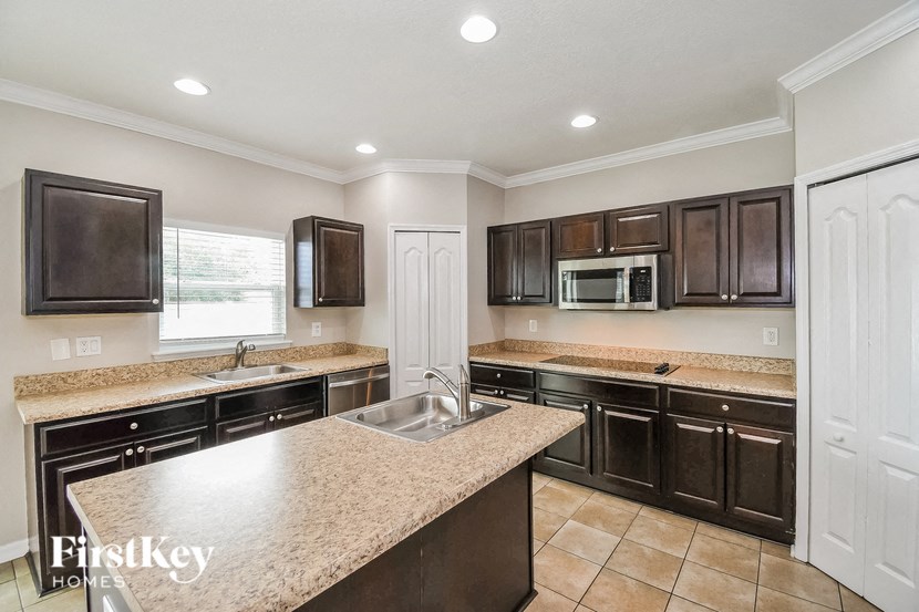 a kitchen with granite counter tops and black cabinets