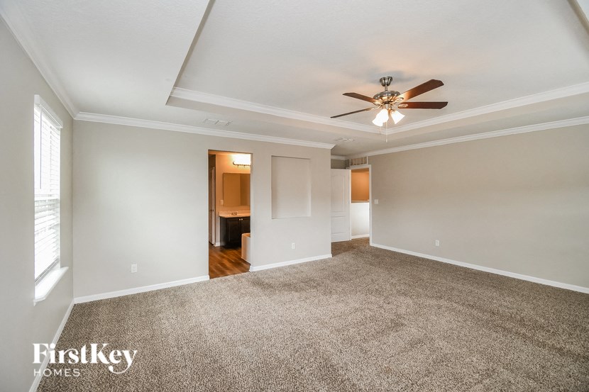 a living room with carpet and a ceiling fan