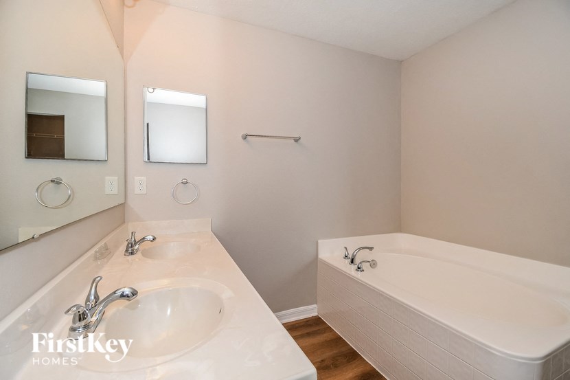 a bathroom with a sink and a tub and a mirror