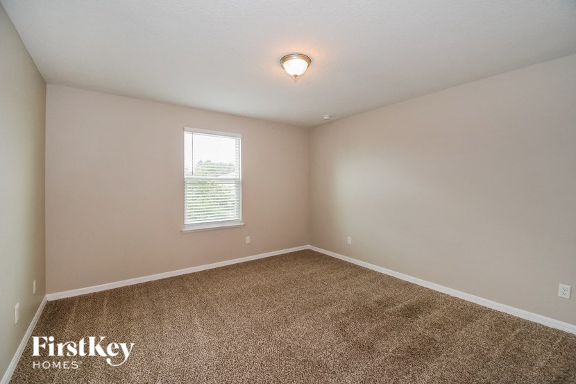 an empty room with carpet and a window