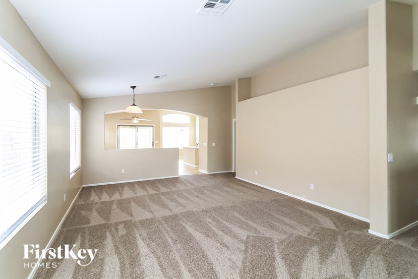 A spacious room with a carpeted floor and a window.