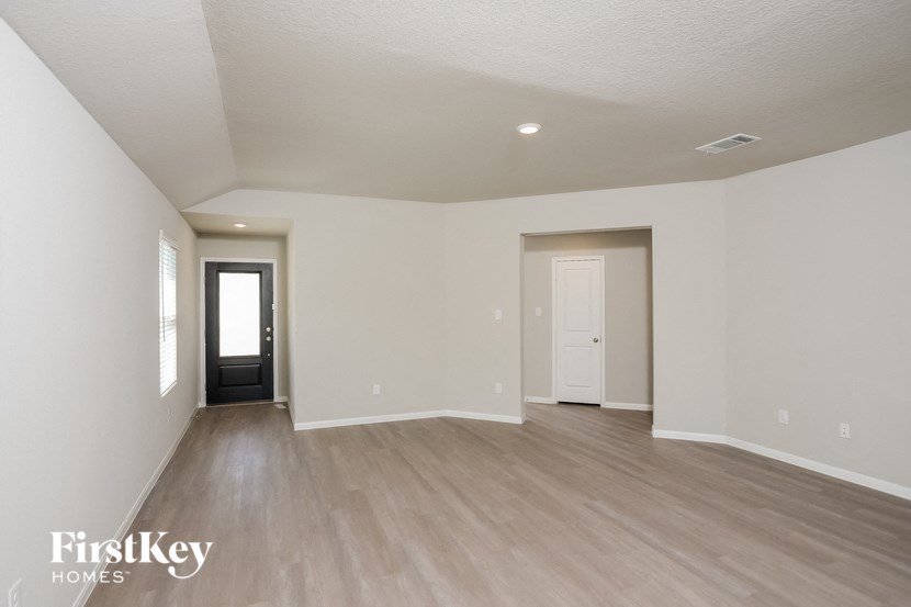 an empty living room with white walls and wood flooring