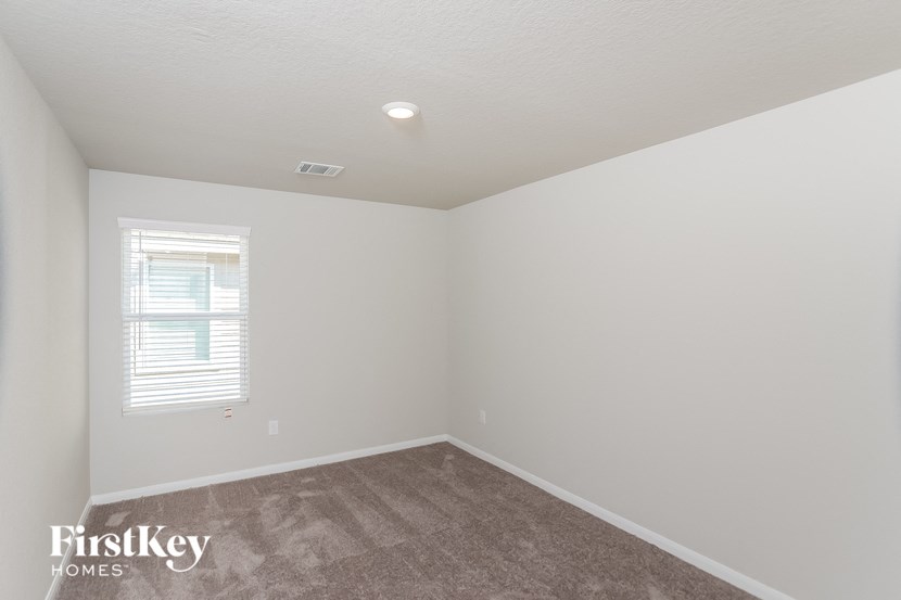 a bedroom with a carpeted floor and a window