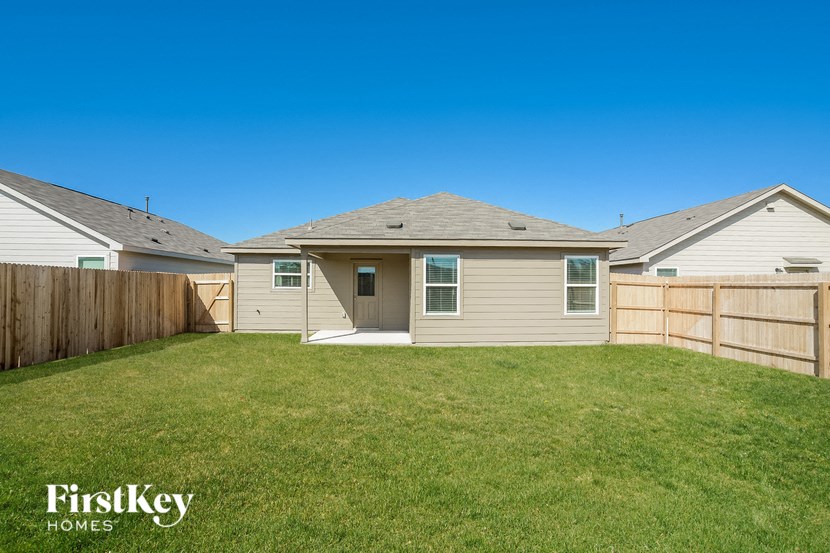 the backyard of a house with a yard and a fence