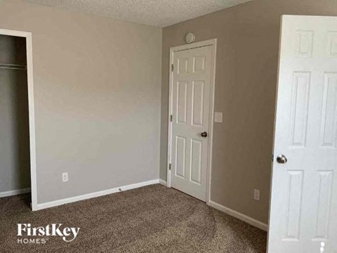 an empty room with a door and a closet
