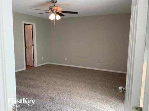 a empty room with a ceiling fan and a door